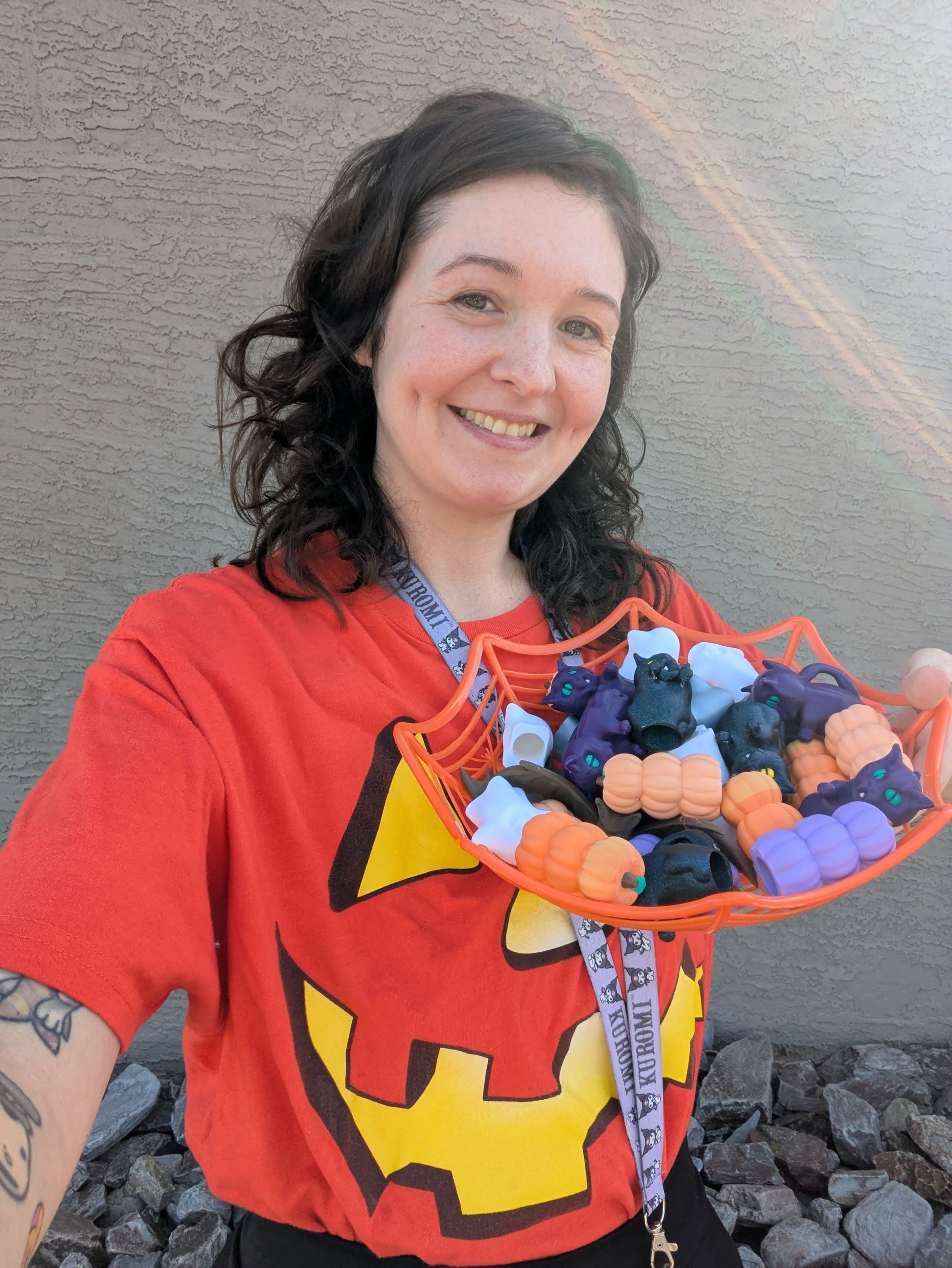 Person holding a basket of colorful plastic toys against a neutral wall.